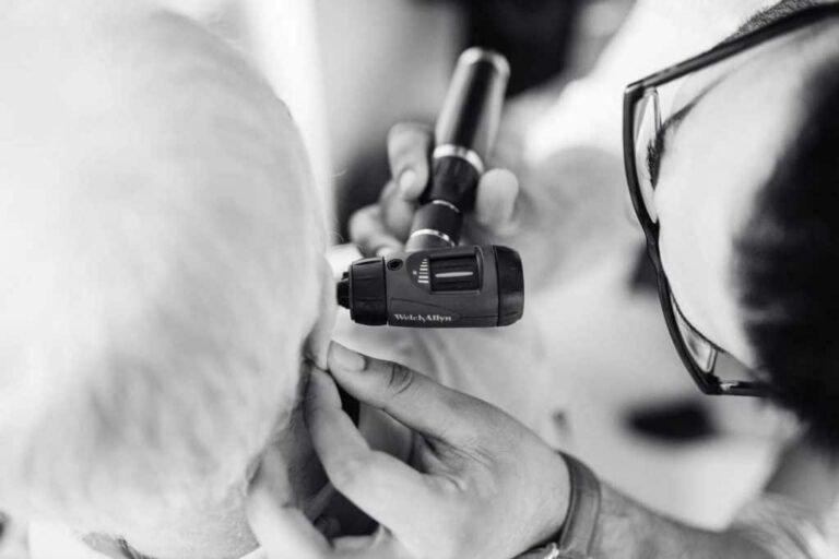 Man having his ear looked at during consultation