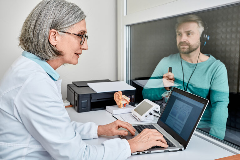 Experienced Female Audiologist Doing Hearing Test To Male Patien