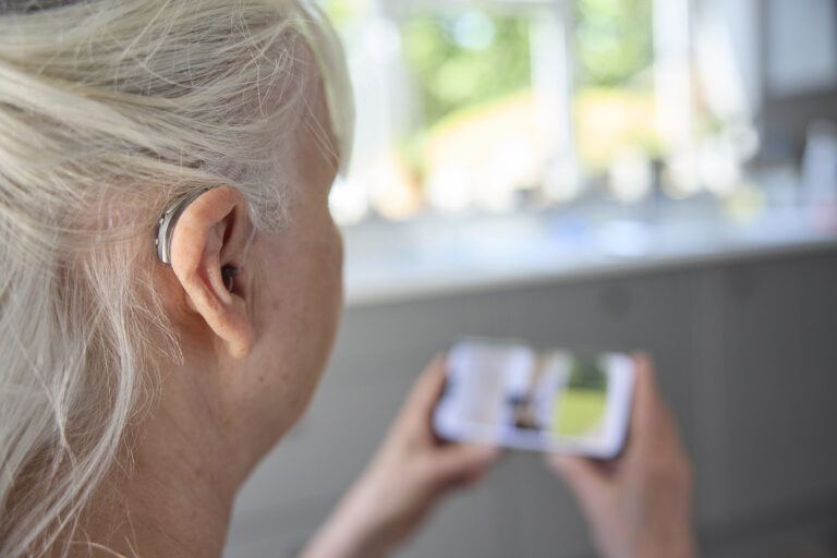 Close Up Of Senior Woman Wearing Behind The Ear Hearing Device O
