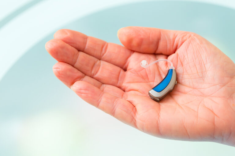 private hearing aids - hand holding small inconspicuous hearing aid