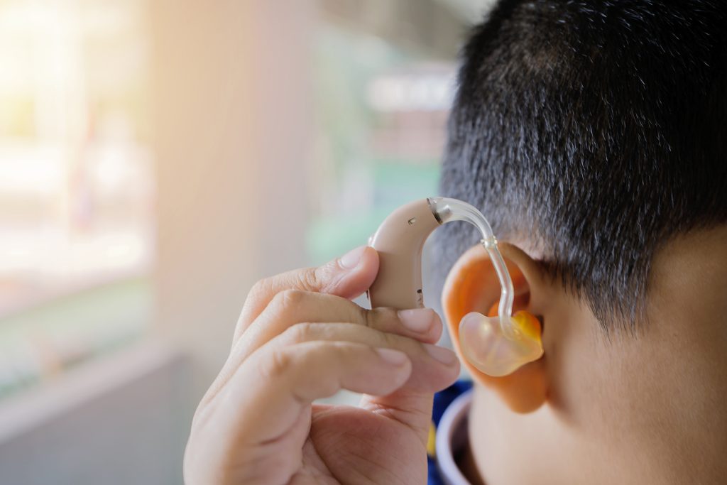 private hearing aids - child is wearing a hearing aid