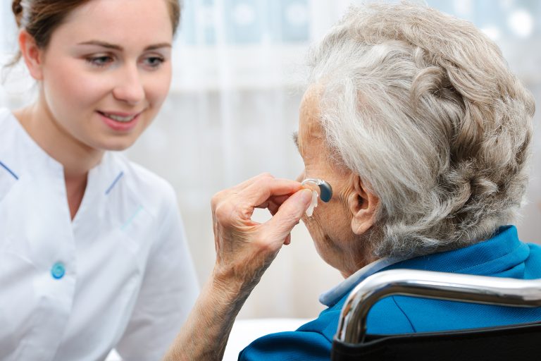 Hearing aid services - Senior-Woman-Trying-Hearing-Aid