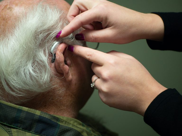 private hearing aids - A-Old-Man-Putting-On-Hearing-Aids